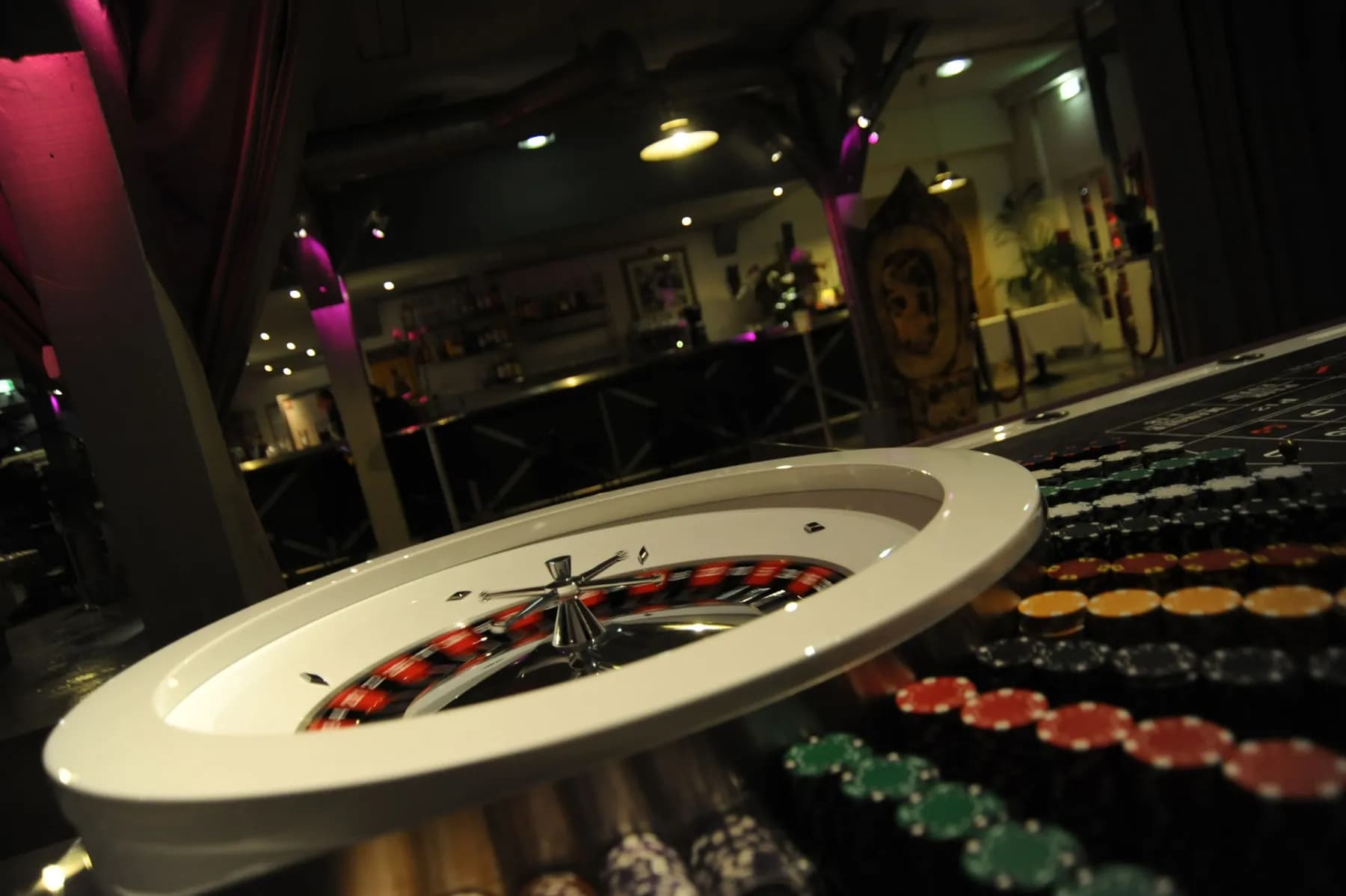 Cuvette blanche de roulette et jetons, dans un loft sombre