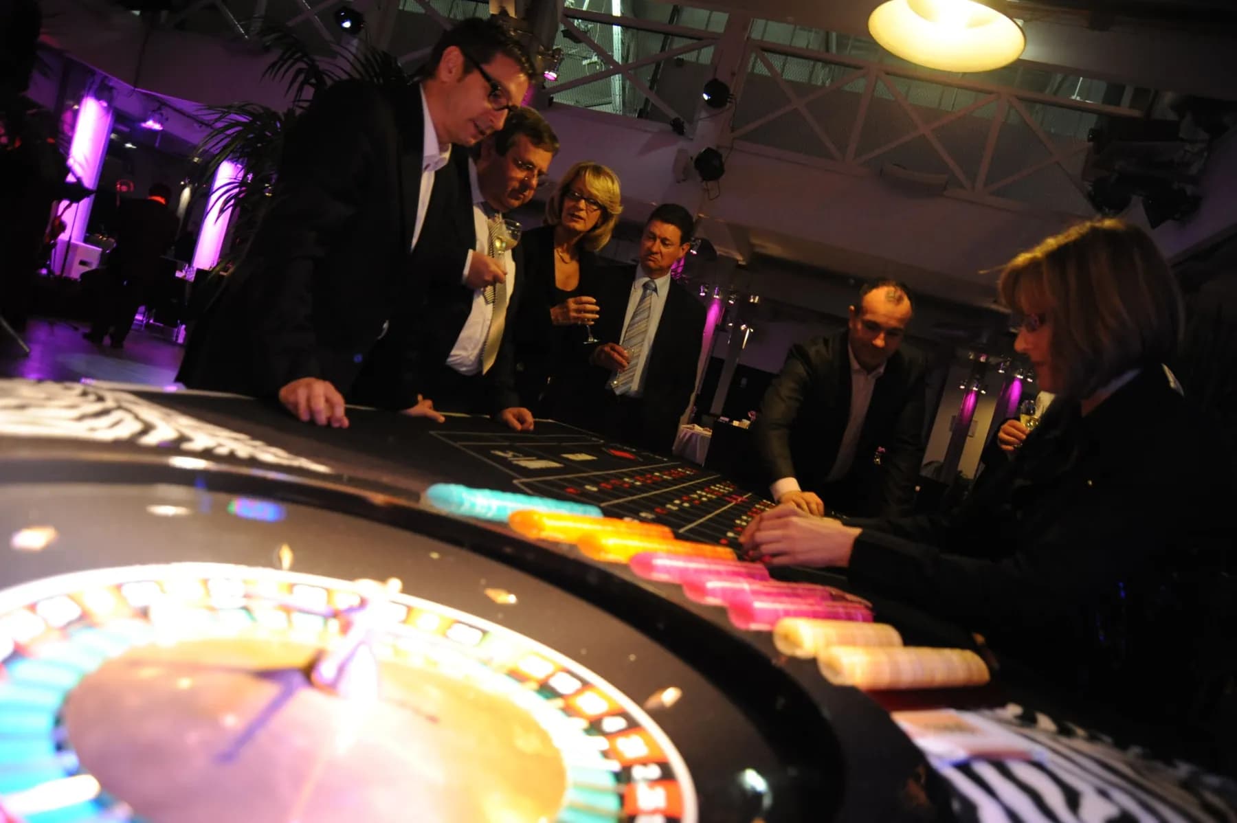 Roulette au premier plan, invités autour de la table