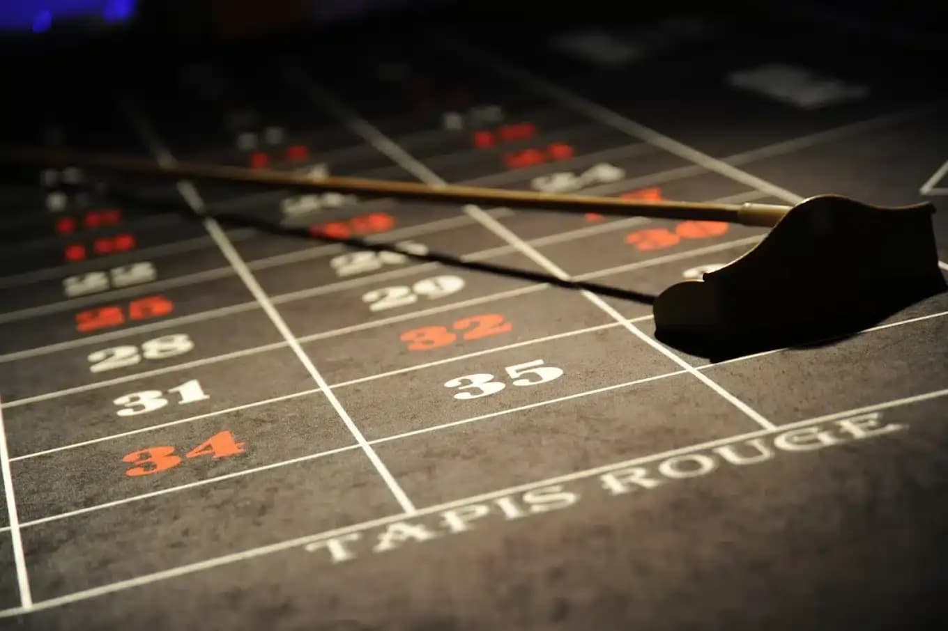 Râteau de croupier sur le tapis de roulette « Tapis Rouge »
