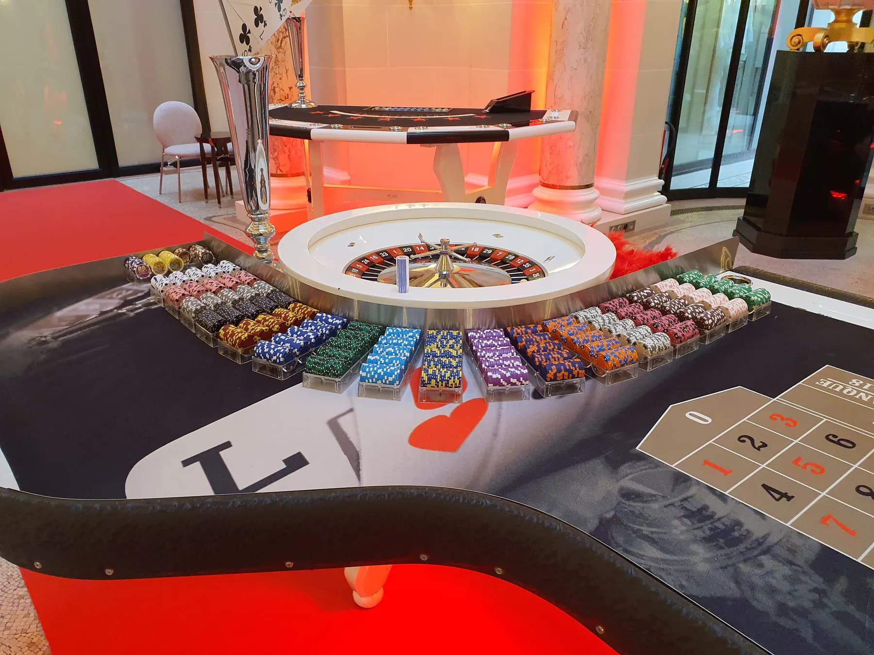 Roulette et tapis de jeu dans un salon baigné de lumière rouge