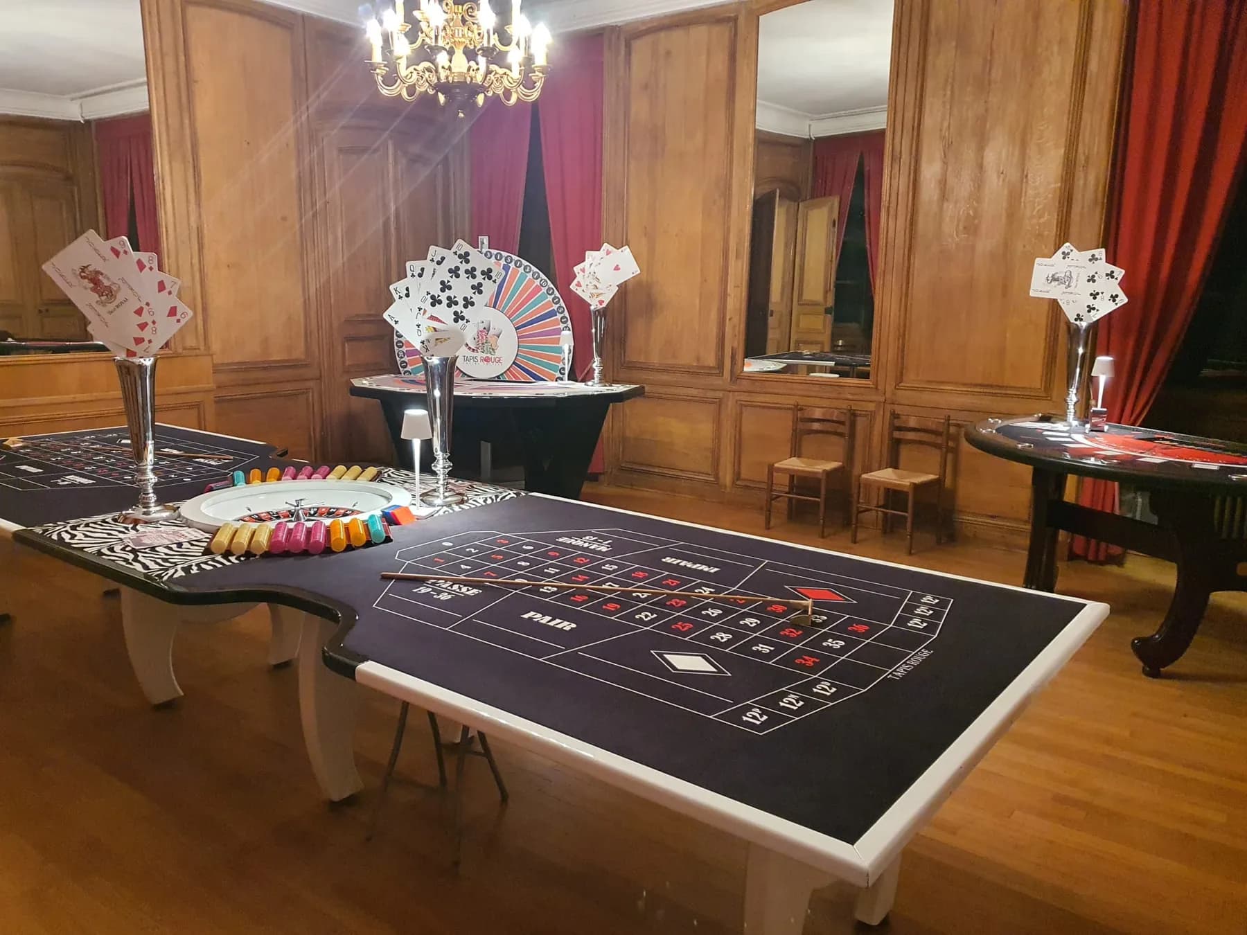 Table de roulette dans un salon aux boiseries, sous un lustre